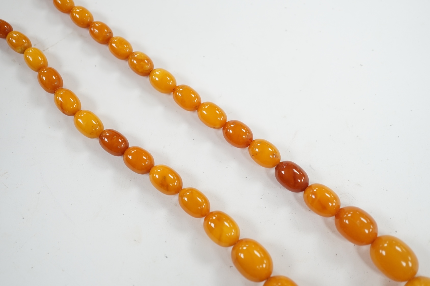 A single strand graduated oval amber bead necklace, 42cm, gross weight 23 grams. Condition - poor to fair